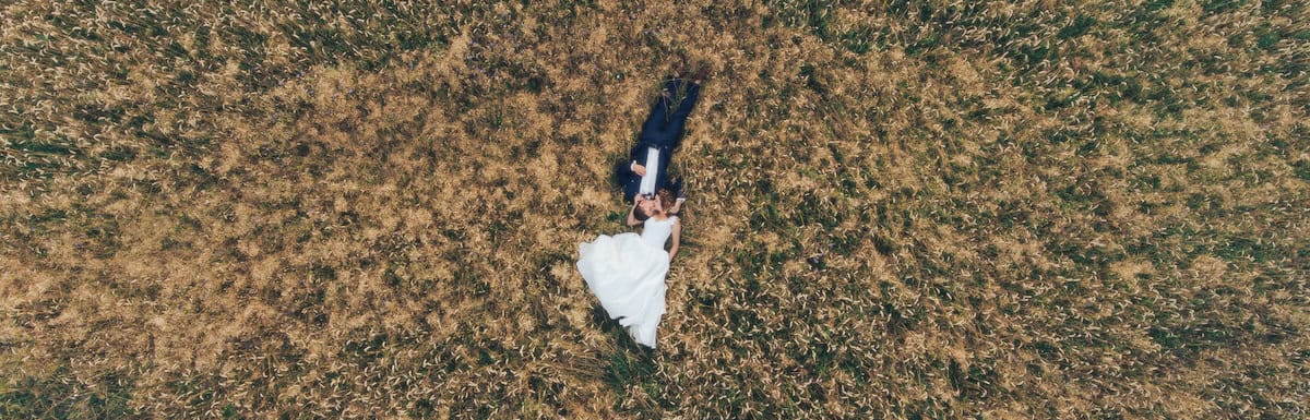 Pareja tumbada sobre el trigo grabada desde dron en vídeo preboda.